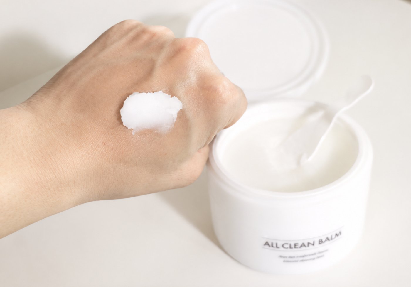 Heimish All Clean Balm swatch on the back of a hand next to the open jar